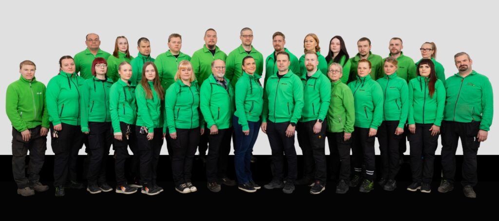 Reijuksen koko henkilöstö, kaikilla vihreät ohuet takit päällä.